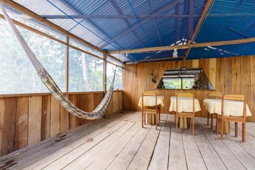 a room with a hammock in the middle of a room with a table at Red Uakari Jungle Lodge in Iquitos