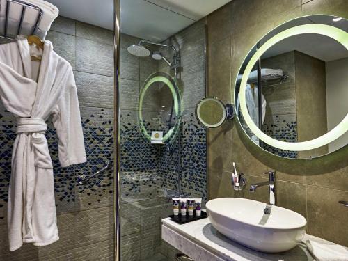 a bathroom with a sink and a shower at Mercure Ismailia Forsan Island in Ismailia