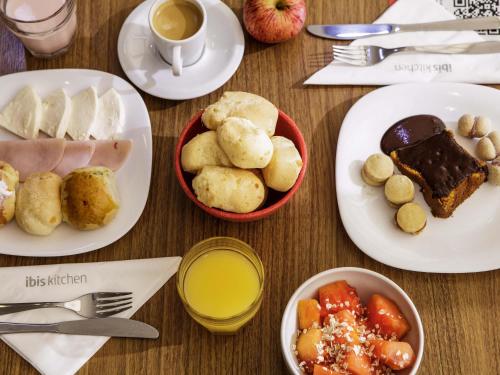 a table with plates of food and a cup of coffee at ibis Sao Jose dos Campos Dutra in São José dos Campos