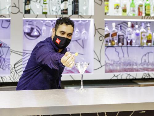a man in a mask points to a glass at ibis Sao Jose dos Campos Dutra in São José dos Campos