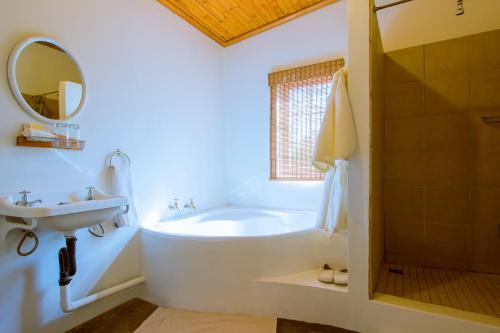 bagno con vasca, lavandino e specchio di The Barracks a Colesberg