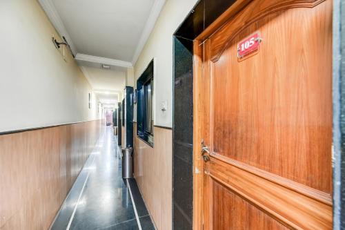 a hallway in a hospital with a wooden door at Hotel O Rourkela Palace in Raghunāthpāli