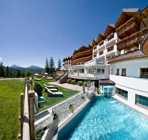 an aerial view of a house with a swimming pool at Hotel Sonnalp in Obereggen