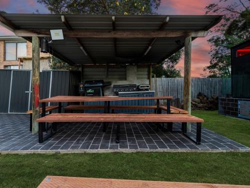 a picnic table under a pavilion in a yard at Skyes Beach House-Views, Spas, Sauna, Arcade Games in Surf Beach