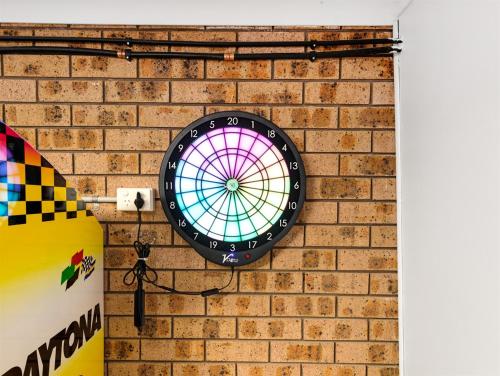 a clock hanging on a brick wall at Skyes Beach House-Views, Spas, Sauna, Arcade Games in Surf Beach