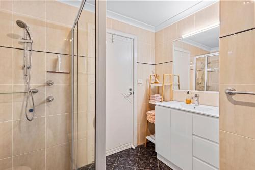 un baño con ducha y lavabo en Sandy Place Beach House managed by Batemans Bay Accom, en Long Beach
