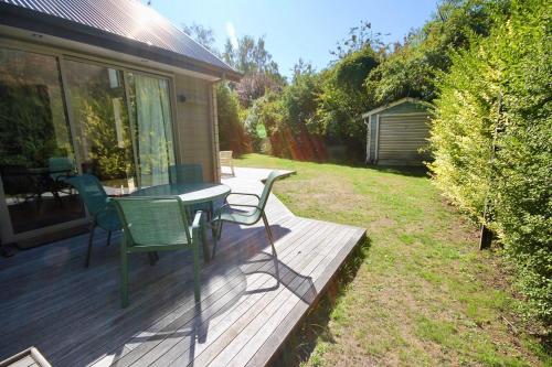 a deck with a table and chairs on a house at 20 Cheltenham Street in Hanmer Springs
