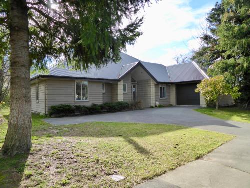 a house with a tree in front of it at 20 Cheltenham Street in Hanmer Springs