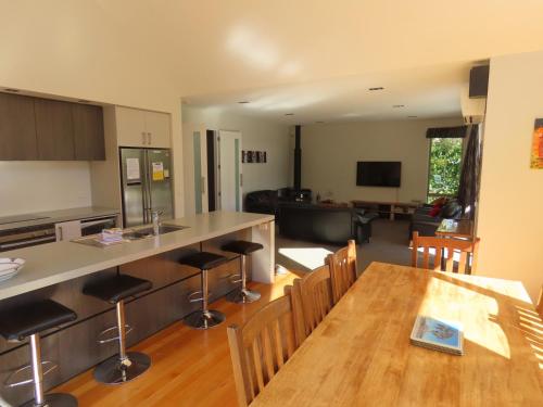 a kitchen and living room with a table and chairs at 20 Cheltenham Street in Hanmer Springs