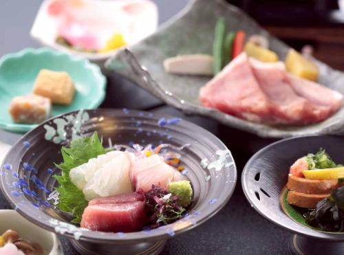 a bowl of food on a table with plates of food at Shikinoyado SAHIMENO in Kawai