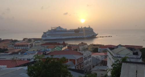 a cruise ship in the ocean at sunset at Peaceful in Town in Saint Georgeʼs