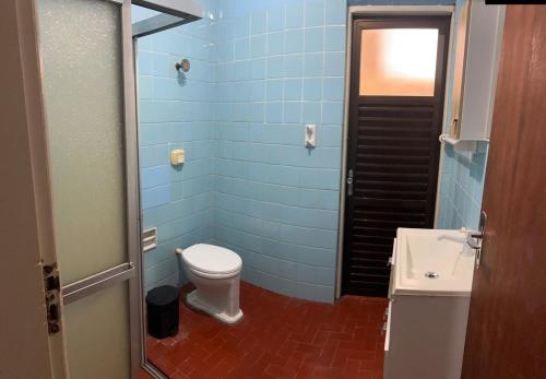 a blue bathroom with a toilet and a sink at Apartment two blocks from the sea, in the center of Torres in Torres