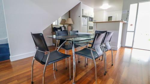 a dining room with a glass table and chairs at Plover Executive Deluxe Villa 25 in Cams Wharf