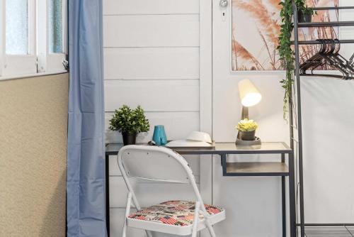ein weißer Stuhl neben einem Schreibtisch mit einer Lampe in der Unterkunft Boutique Single Room - Centrally Located at Granville -In Courtyard - Shared Bathroom & Kitchen in Sydney