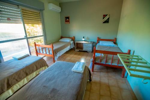 a room with two beds and a window at Rio Uruguai Pousada in Uruguaiana