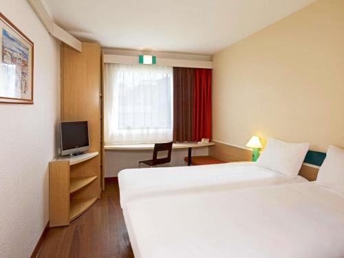 ザブジェにあるIbis Katowice - Zabrzeのベッド2台とテレビがあるホテルの部屋