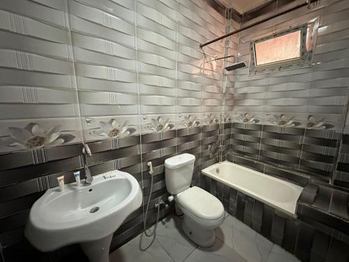 um banheiro com uma pia, um vaso sanitário e uma banheira em Upora Pyramids View Inn em Cairo