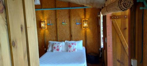 a bedroom with a bed in a wooden wall at Suite Shambhala Ideal para Casal Beira Mar entre Paraty e Ubatuba in Ubatuba