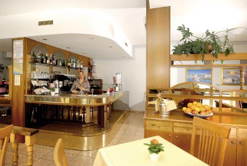 Eine Frau, die hinter einer Bar in einem Restaurant steht. in der Unterkunft Albergo Savoia in Ospedaletti