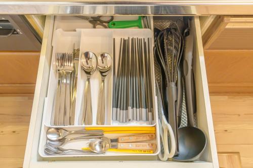 a drawer filled with utensils in a cabinet at ジブリパークまで車10分 遊べるキッズハウス1棟貸切り 敷地内無料駐車場あり 最大12名 in Seto
