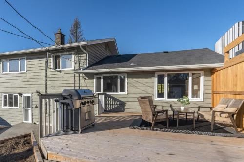 a house with a deck with a grill and chairs at Great Northern Escapes - The Managers House in Yellowknife