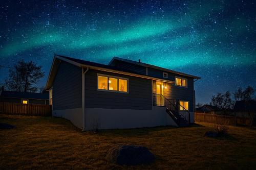 a house with the northern lights in the sky at Great Northern Escapes - The Managers House in Yellowknife