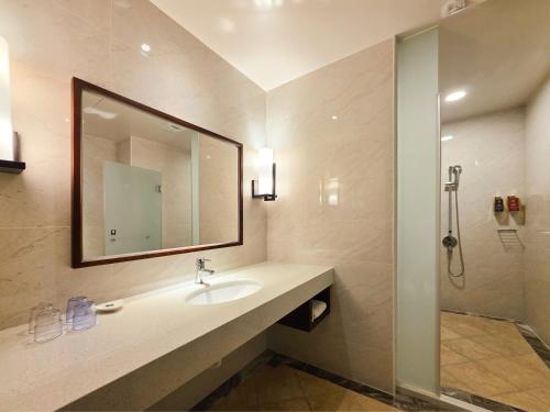 Un baño con lavabo, espejo y ducha. en 雀客旅館台中來來, en Taichung