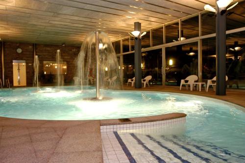 a swimming pool with a fountain in a building at Andorra Palace in Andorra la Vella