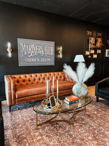 a brown leather couch in a living room with a table at New! 4-Story Villa, Private Rooftop, Pool and Marina in Key Largo in Key Largo