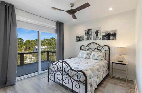 a bedroom with a bed and a balcony at The Repose at Seven One Seven in Saint George Island