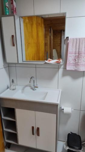 a bathroom with a sink and a mirror at Morada dos Lagos in São José dos Ausentes