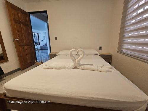 a bed with two swans made out of towels at Casa Burbujas in Puerto Jiménez