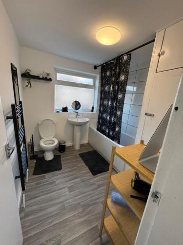 a bathroom with a toilet and a tub and a sink at City Escape Stylish 4 bedroom house in Nottingham in Nottingham