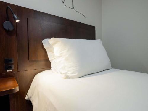 a white pillow sitting on top of a bed at Mercure Jaragua do Sul in Jaraguá do Sul