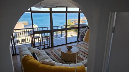 Una sala de estar con un sofá y vista al mar. en Le Blu Mile apartement, en Wollongong