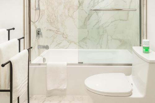 Un baño blanco con ducha y WC. en Deep Cove holiday, en North Vancouver