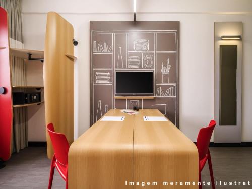 a conference room with a table and a television at ibis Guarulhos Aeroporto in Guarulhos