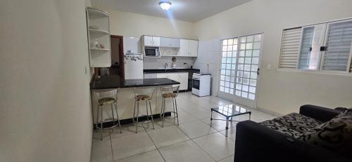 a living room with a couch and a kitchen at Casa Aconchegante in Cuiabá