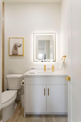 a white bathroom with a toilet and a sink at LUXE - Nouveau - Sparkling Pool - Walk to Old Town in Scottsdale