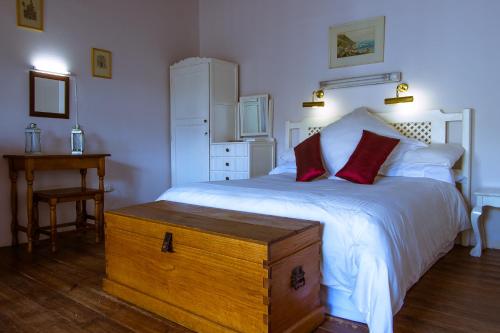 a bedroom with a large white bed with red pillows at The Barracks in Colesberg
