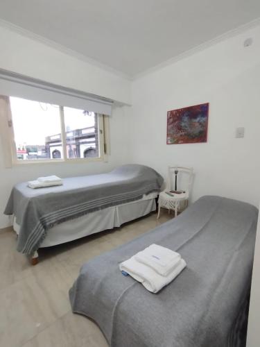 two beds in a white room with a window at Catalina - Excelente ubicacion en pleno centro - 1B in Santa Fe