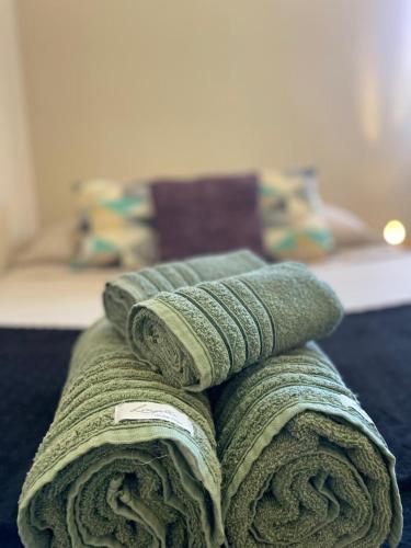 a pile of towels sitting on top of a bed at Apartamento moderno perto do centro e praia! in Búzios