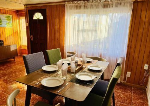 a dining room table with chairs and a table and a table and chairsktop at Casa Refugio Austral, hasta 6 personas, cerca Mall Pionero, Zona Franca y Centro in Punta Arenas