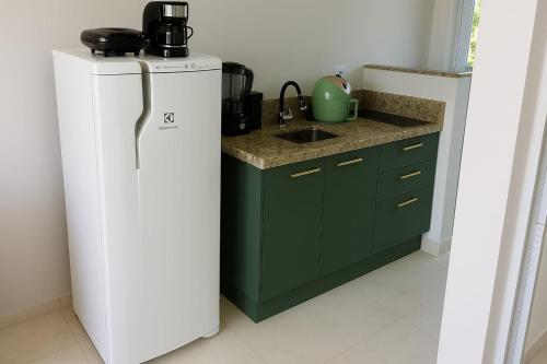 Una cocina con un refrigerador blanco y un fregadero. en Residencial Vista Verde, en Ourinhos