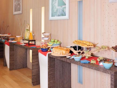 a buffet line with various food items on display at Novotel Monte-Carlo in Monte Carlo