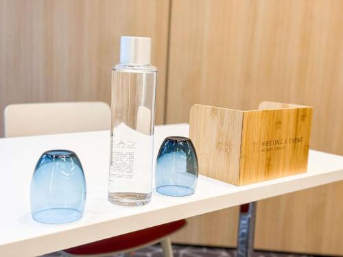 a bottle and two glasses sitting on a table at Novotel Monte-Carlo in Monte Carlo