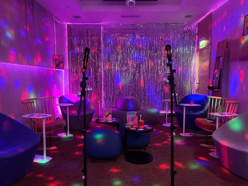 a room with purple and pink lights and stools at Novotel Monte-Carlo in Monte Carlo
