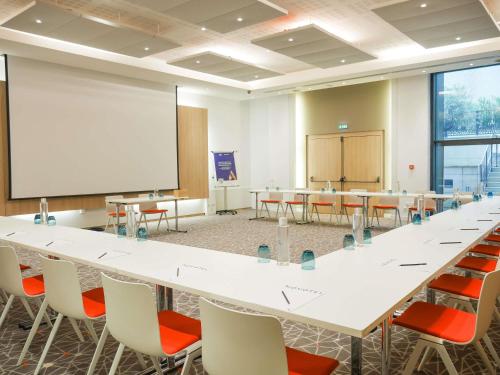 a conference room with tables and chairs and a whiteboard at Novotel Monte-Carlo in Monte Carlo