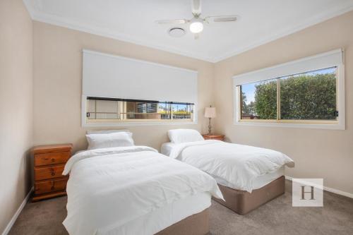 a bedroom with two beds and a window at Tide view in Toukley