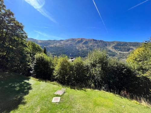 a green field with trees and mountains in the background at Appartement chaleureux près des pistes à Méribel - FR-1-688-100 in Mussillon